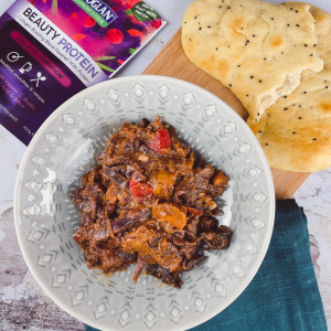 Bowl of vegan red cabbage curry with Bioglan Superfoods Beauty Protein and naan bread