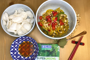 Bowl Singapore Noodles with Bioglan Superfoods Supergreens, prawn crackers, sweet chilli sauce, chopsticks and peanuts scattered